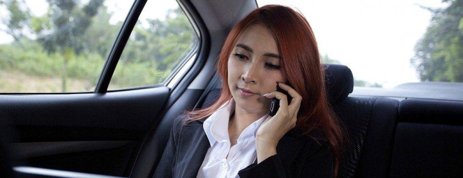 Woman speaking on cell phone in back seat of a town car